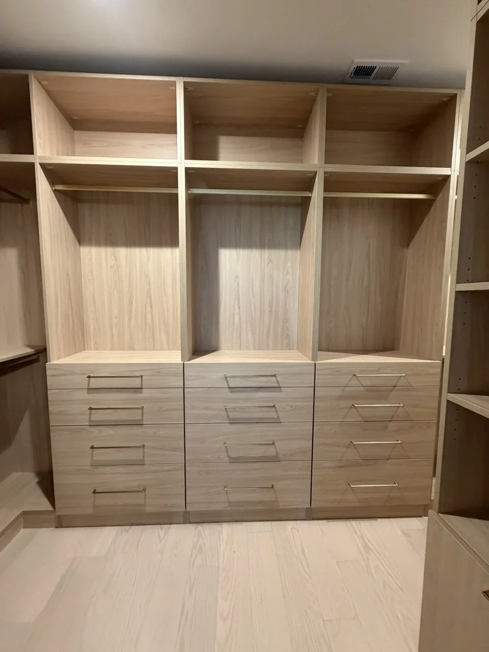 Custom walk-in closet with a full-width drawer bank, designed and installed in an Atlanta home