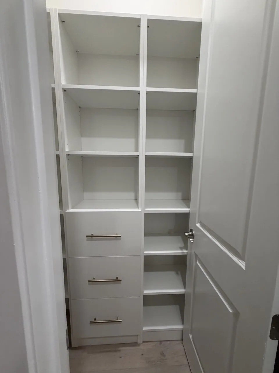 Reach-in pantry cabinet with adjustable shelving and a three-drawer stack
