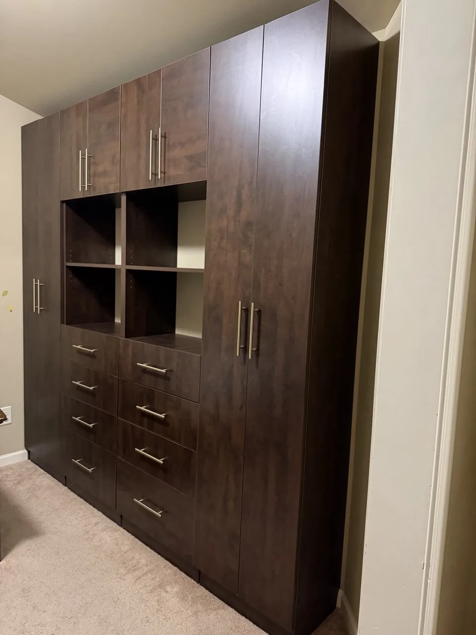 Espresso wardrobe wall with open cubbies and brushed gold hardware